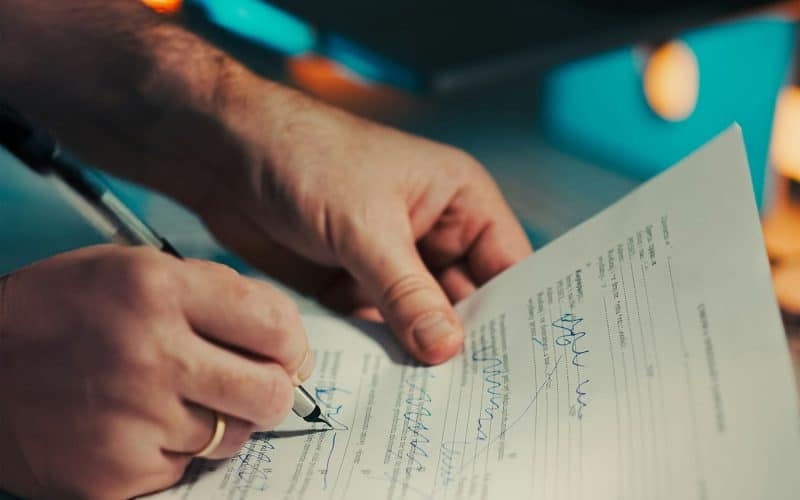 Buyer reading and signing a pre-sale purchase contract